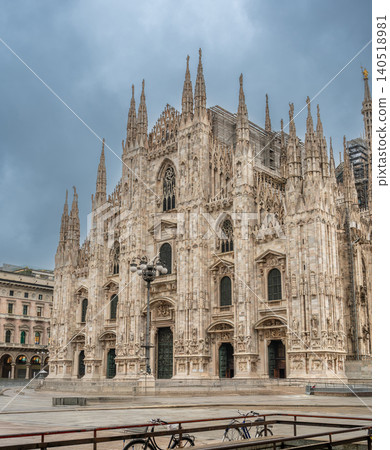Milan, italy, october 2, 2024. Milan cathedral, a landmark of gothic architecture, standing prominently in an empty city square on a cloudy autumn day Milan, italy, october 2, 2024. Milan cathedral, a landmark of gothic architecture, standing prominently in an empty city square on a cloudy autumn day 140518981