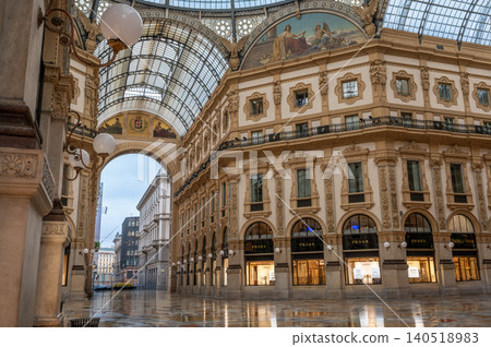 Milan, italy, october 2, 2024. Historic galleria vittorio emanuele ii with architectural details and luxury stores reflecting on the wet floor Milan, italy, october 2, 2024. Historic galleria vittorio emanuele ii with architectural details and luxury stores reflecting on the wet floor 140518983