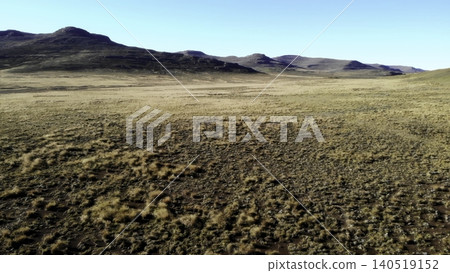 Expansive Sunny Plains. Media. Vast Stretch Of Yellow Grassland Under Warm Sunlight With Faraway Hills In View Expansive Sunny Plains. Media. Vast Stretch Of Yellow Grassland Under Warm Sunlight With Faraway Hills In View 140519152