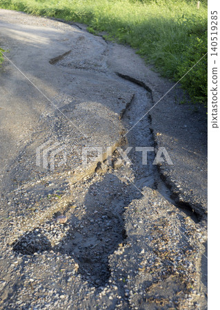 Badly eroded dirt road with deep cracks and washed out soil after heavy rain Badly eroded dirt road with deep cracks and washed out soil after heavy rain 140519285