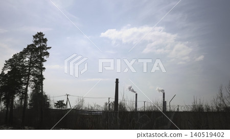 Forgotten Industrial Site At Forest Boundary. Rusting Chimney And Graffiti Fence Against Cloudy Sky . Media 140519402