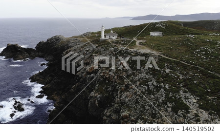 Aerial Lighthouse Outpost With Adjacent Dwellings, Connecting Paths, Rocky Promontory, Calm Sea, Evening Light. Media Aerial Lighthouse Outpost With Adjacent Dwellings, Connecting Paths, Rocky Promontory, Calm Sea, Evening Light. Media 140519502
