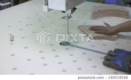 Trained Operator With Gloves Precisely Arranges Fabric Around Guide For Exact Trimming Process. Media Trained Operator With Gloves Precisely Arranges Fabric Around Guide For Exact Trimming Process. Media 140519598