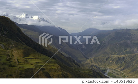 Vivid Depiction Of Sunlit Terraces Cascading Down Rugged Slopes With Drifting Clouds In Background. Creative 140519626