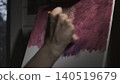 Close Portrait Of Hobbyist Artist Applying Textured Magenta Paint To Abstract Art In Subdued Illumination . Media 140519679