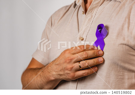 Man wearing a purple ribbon demonstrating support for health awareness 140519802