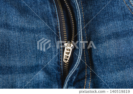 Closeup view of a denim zipper on casual blue jeans Closeup view of a denim zipper on casual blue jeans 140519819