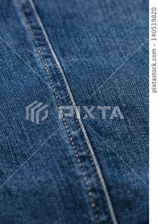 Closeup view of blue denim fabric with visible stitching details Closeup view of blue denim fabric with visible stitching details 140519820