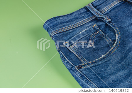 Denim jeans with pocket detail and flat lay on a green background Denim jeans with pocket detail and flat lay on a green background 140519822