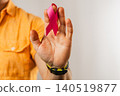 Man holding pink awareness ribbon in studio for healthcare support 140519877
