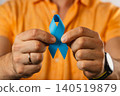 Person holds blue ribbon to show support for health awareness campaign 140519879