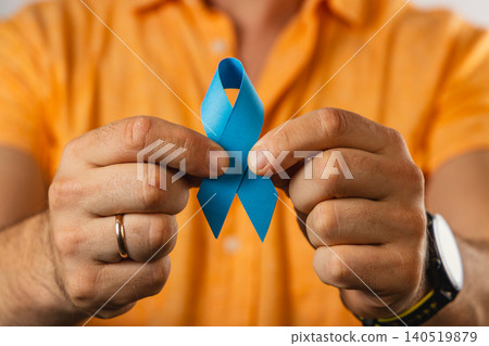 Person holds blue ribbon to show support for health awareness campaign 140519879