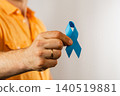Man holds blue awareness ribbon for health support and advocacy 140519881