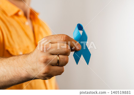 Man holds blue awareness ribbon for health support and advocacy 140519881