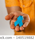 Support for health awareness with a blue ribbon in a person's hand 140519882