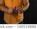 Man holds a purple awareness ribbon showing support for healthcare initiatives 140519888