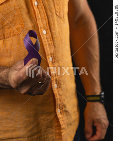 Supporting health awareness with a purple ribbon in hands 140519889