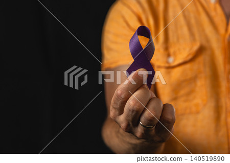 Man holds purple awareness ribbon to support health campaign 140519890