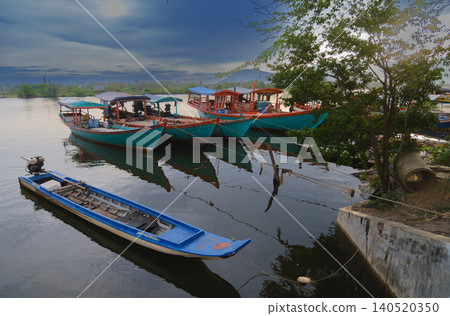Colorful traditional fishing boats moored on Kampot river Cambodia at dawn Colorful traditional fishing boats moored on Kampot river Cambodia at dawn 140520350