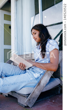 Young woman enjoying reading book on outdoor patio Young woman enjoying reading book on outdoor patio 140520522