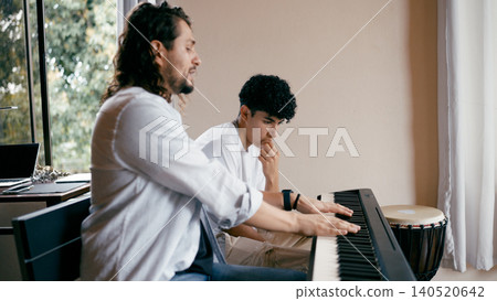 Music teacher instructing student during piano lesson Music teacher instructing student during piano lesson 140520642