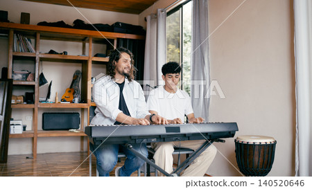 Teacher giving keyboard lesson to student at home Teacher giving keyboard lesson to student at home 140520646