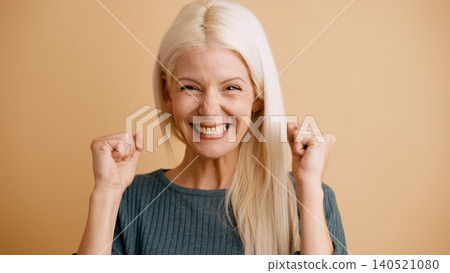 Happy senior woman celebrating success with fists up Happy senior woman celebrating success with fists up 140521080