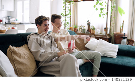 Happy young men enjoying movie night at home Happy young men enjoying movie night at home 140521129