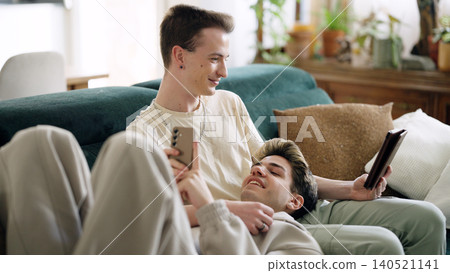 Gay couple relaxing on sofa enjoying intimate moment Gay couple relaxing on sofa enjoying intimate moment 140521141