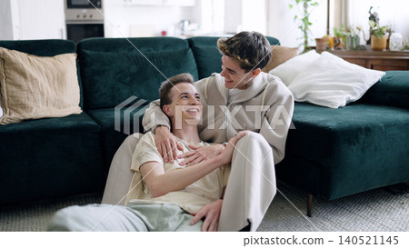 Happy male couple embracing, relaxing home living room Happy male couple embracing, relaxing home living room 140521145