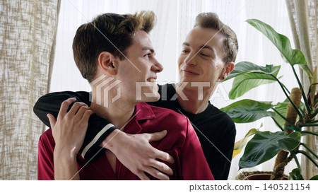Young gay couple expressing affection and smiling at home 140521154