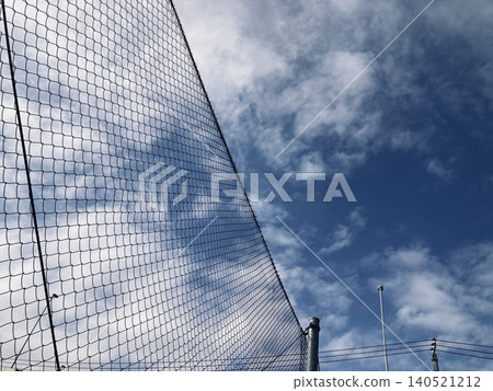 Blue sky reflected in the net fence 140521212