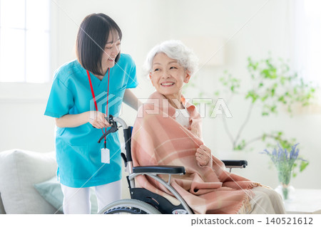 Elderly person in a wheelchair and a young female caregiver Elderly person in a wheelchair and a young female caregiver 140521612