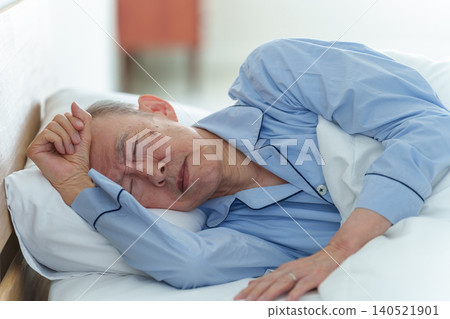 An elderly man in poor health resting in bed. An elderly man in poor health resting in bed. 140521901