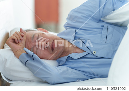 An elderly man in poor health resting in bed. An elderly man in poor health resting in bed. 140521902