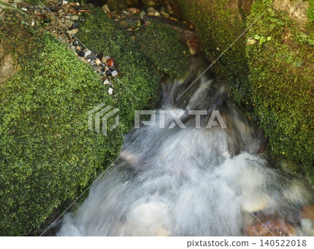 Spring water flowing into a clear stream Spring water flowing into a clear stream 140522018
