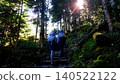 Hikers making their way through the forest bathed in the morning sun. 140522122
