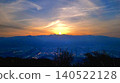 The setting sun sinking behind the mountain range and the fantastical sky 140522128