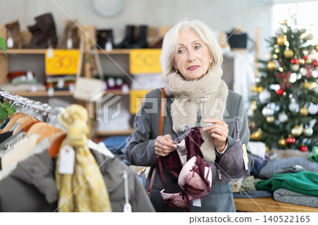 Mature woman choosing a bra in a Christmas shop Mature woman choosing a bra in a Christmas shop 140522165