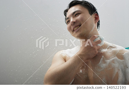 A man in his twenties taking a shower A man in his twenties taking a shower 140522193