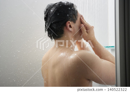 A man in his twenties taking a shower A man in his twenties taking a shower 140522322