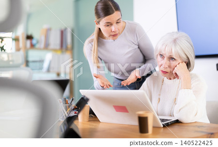Female boss yells at senior woman employee, pensioner work at computer Female boss yells at senior woman employee, pensioner work at computer 140522425