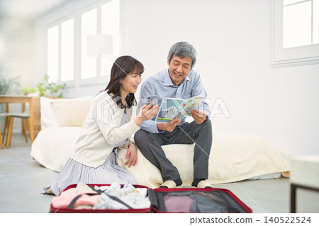 A smiling senior couple preparing for a trip. A smiling senior couple preparing for a trip. 140522524