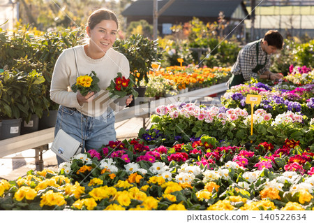 Young woman choosing a primrose Young woman choosing a primrose 140522634