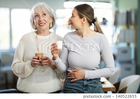 Two businesswomen drink coffee and discuss news during a break in office. Coffee break Two businesswomen drink coffee and discuss news during a break in office. Coffee break 140522655