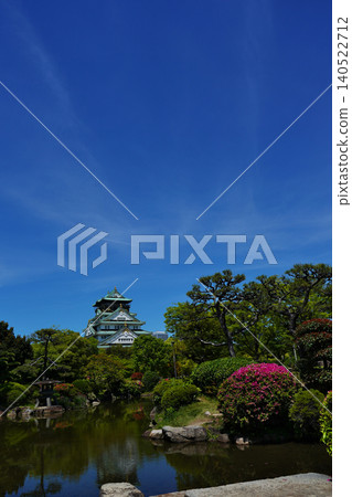 The majestic appearance of Osaka Castle, one of Japan's most famous castles, viewed from a Japanese garden. 140522712