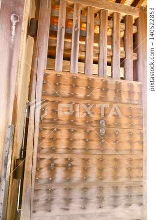 Traditional architecture featuring a heavy wooden gate and studded doors. Traditional architecture featuring a heavy wooden gate and studded doors. 140522853