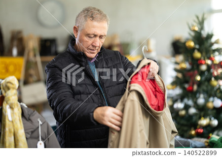 elderly man chooses a trench coat elderly man chooses a trench coat 140522899
