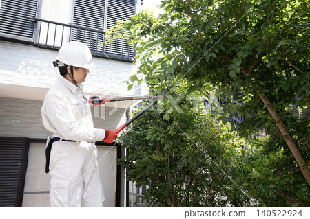 工人們正在修剪花園裡的樹木 工人們正在修剪花園裡的樹木 140522924