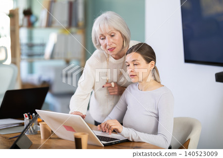 Senior female boss help to woman interns with laptop task Senior female boss help to woman interns with laptop task 140523009